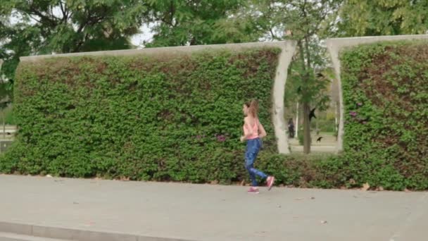公園で走っているフィット女性のスローモーション映像 朝スポーツの訓練 — ストック動画