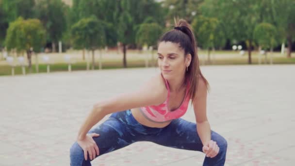 Läuferisch fitte Frau wärmt sich vor Sporttraining im Park auf. — Stockvideo