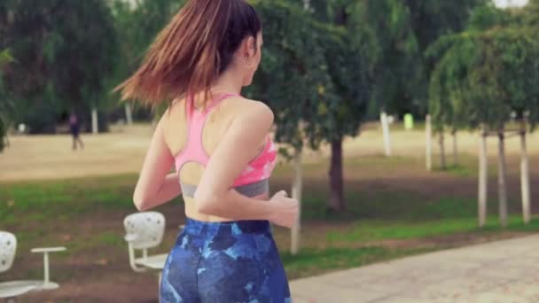 Медленное видео, где в парке бегает подходящая женщина. спортивная подготовка — стоковое видео