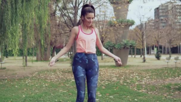 Fit mooie vrouw met springtouw in een park — Stockvideo