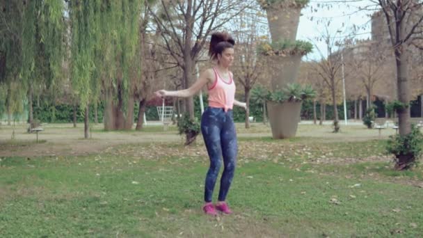 Ajuste hermosa mujer con saltar la cuerda en un parque — Vídeos de Stock