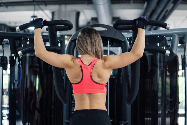 Mujer en forma joven haciendo ejercicio en el gimnasio —  Fotos de Stock