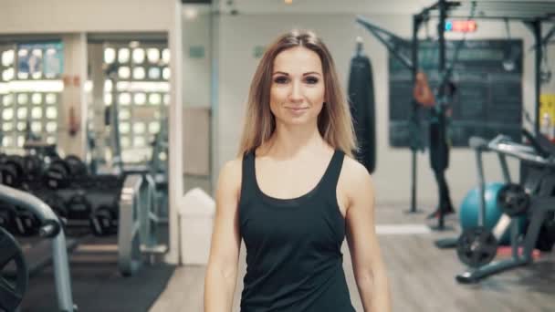 Fotografía en cámara lenta de la mujer en forma joven caminando a través del gimnasio . — Vídeos de Stock