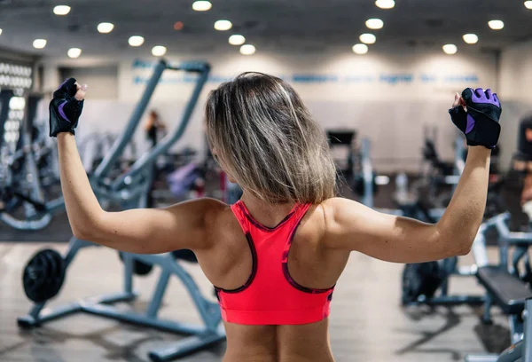 Fitness trainer looks into the camera in the gym