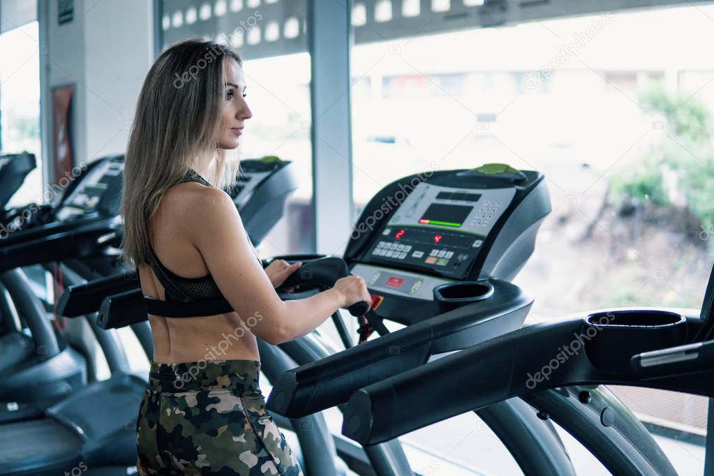 Young fit woman doing running exercise in gym