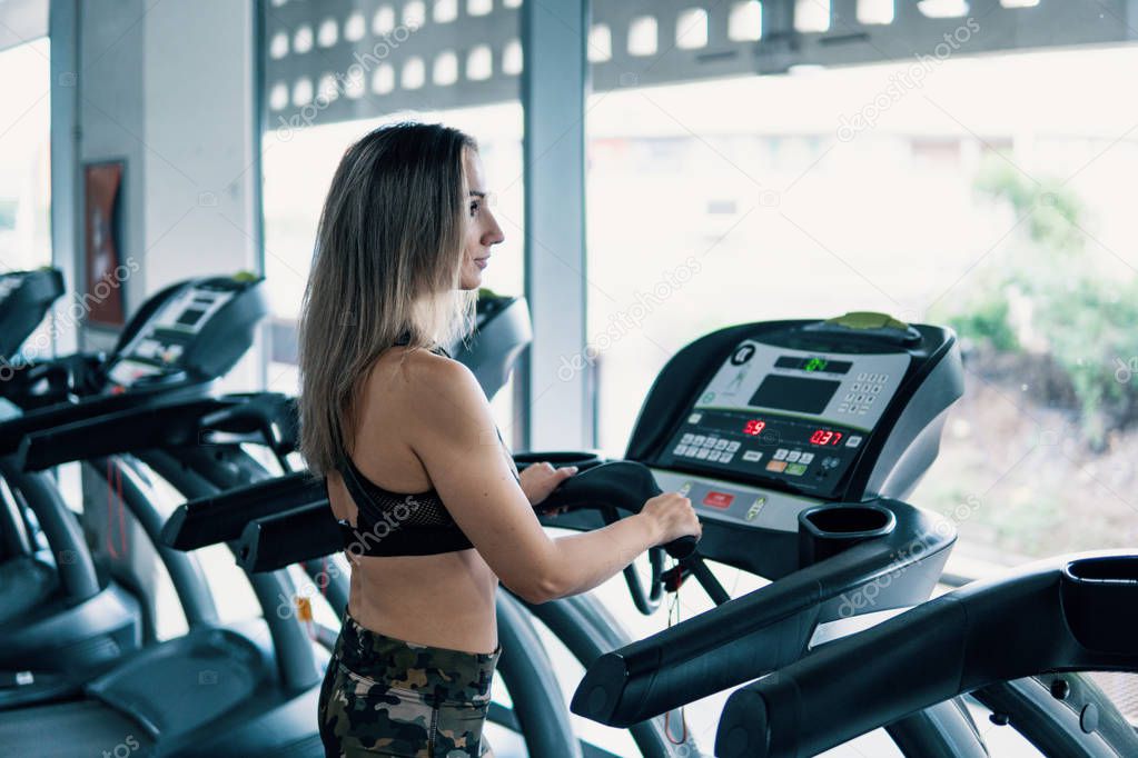 Young fit woman doing running exercise in gym