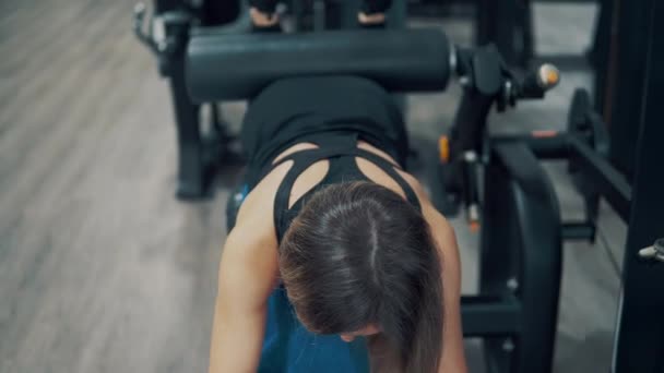 Женщина делает упражнения для ног и ягодиц мышц в тренажерном зале — стоковое видео