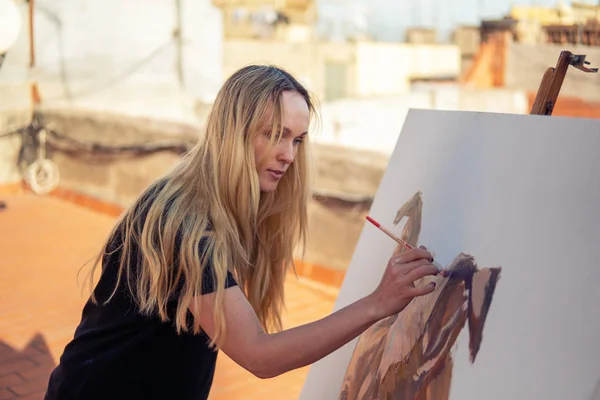 Jeune femme peintre dessin à la maison toit — Photo