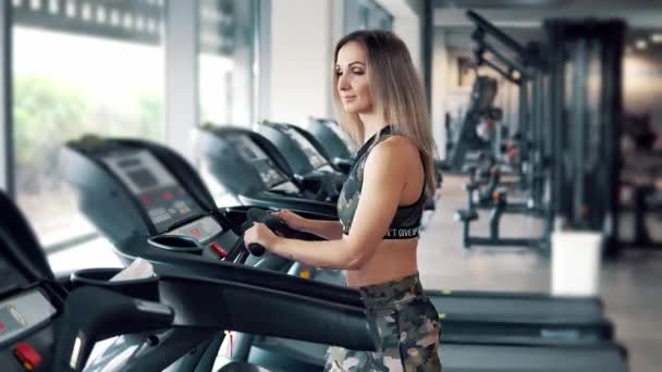 Молода підходить жінка робить вправи в тренажерному залі — стокове відео