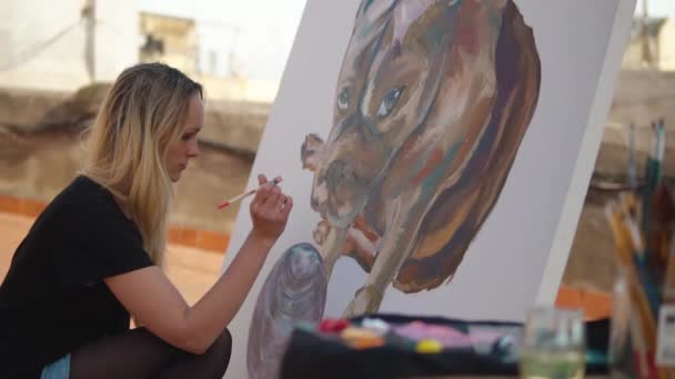 Ung kvinnemalerier tegner på taket – stockvideo