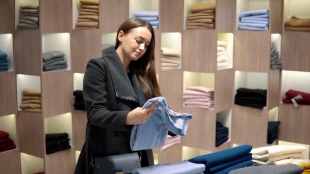 Mooie jongedame vinden zichzelf nieuwe kleding in een winkel-supermarkt — Stockvideo