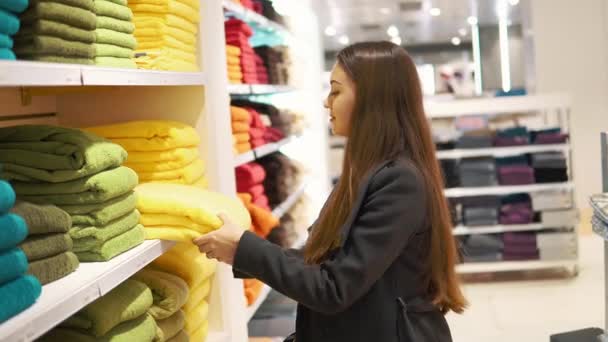 Mujer encontrándose nuevas toallas en una tienda de supermercados — Vídeos de Stock