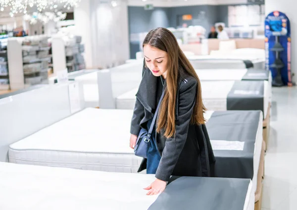 Customer woman buying new furniture - bed in a store