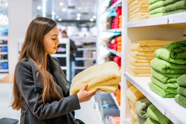 Mujer encontrándose nuevas toallas en una tienda de supermercados — Foto de Stock