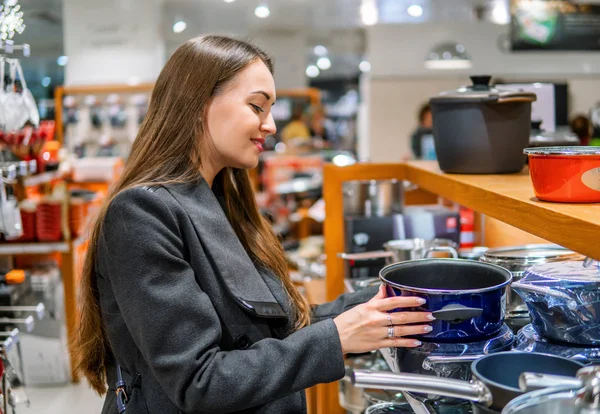 Bela mulher escolhendo pratos utensílios em um supermercado loja — Fotografia de Stock