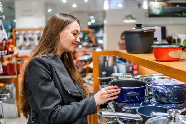 Bela mulher escolhendo pratos utensílios em um supermercado loja — Fotografia de Stock