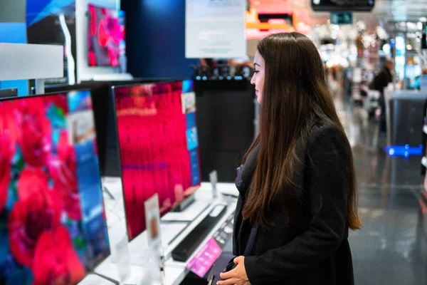 Cliente feminino moderno inteligente escolhendo grandes aparelhos de TV — Fotografia de Stock