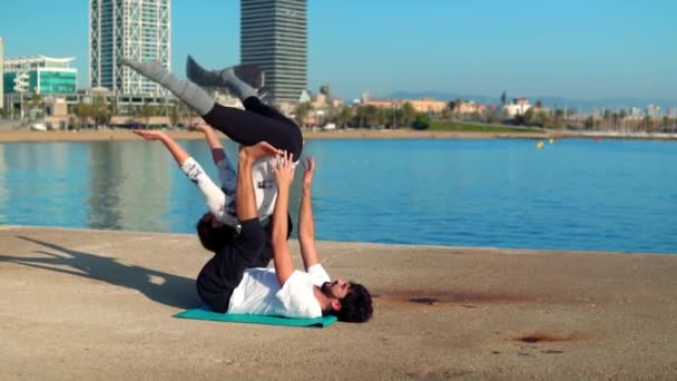 Hermosa pareja practicando acro yoga por la mañana — Vídeos de Stock