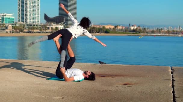 Hermosa pareja practicando acro yoga por la mañana — Vídeos de Stock