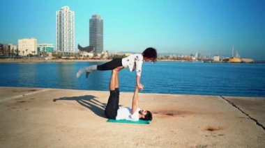 Güzel çift pratik acro yoga sabah havada denize yakın. Denge ve bağlantı kavramı. atış slowmotion