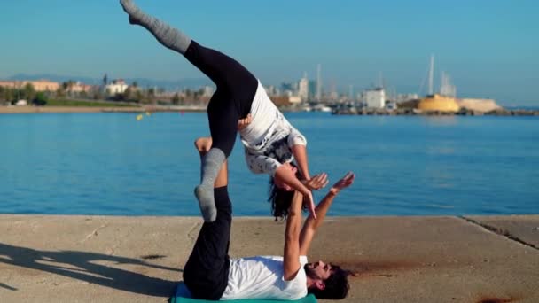 Hermosa pareja practicando acro yoga por la mañana — Vídeo de stock