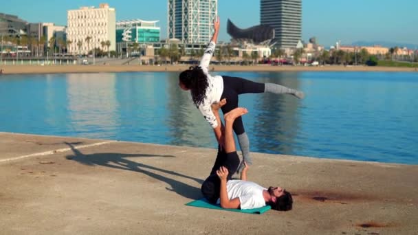 Hermosa pareja practicando acro yoga por la mañana — Vídeos de Stock