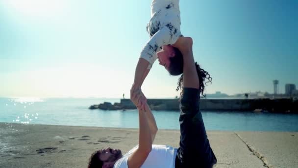 Hermosa pareja practicando acro yoga por la mañana — Vídeo de stock