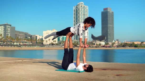 Hermosa pareja practicando acro yoga por la mañana — Vídeos de Stock