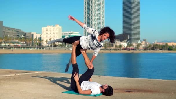 Hermosa pareja practicando acro yoga por la mañana — Vídeos de Stock