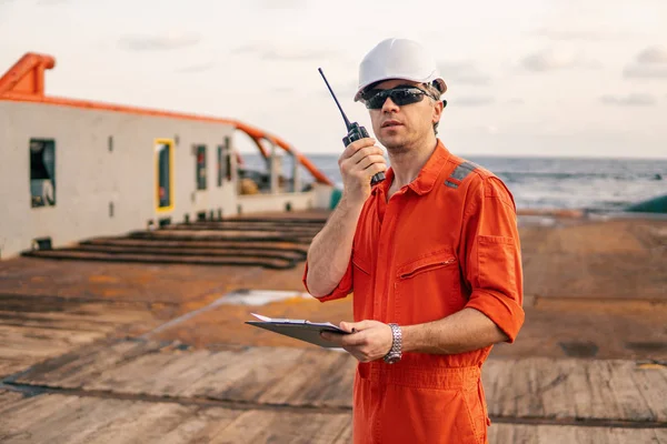 Oficial de cubierta en cubierta del buque de alta mar sostiene radio walkie-talkie VHF — Foto de Stock