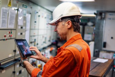 Motoru kontrol odasında dijital tablet izlerken deniz baş mühendis