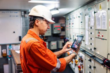 Motoru kontrol odasında dijital tablet izlerken deniz baş mühendis