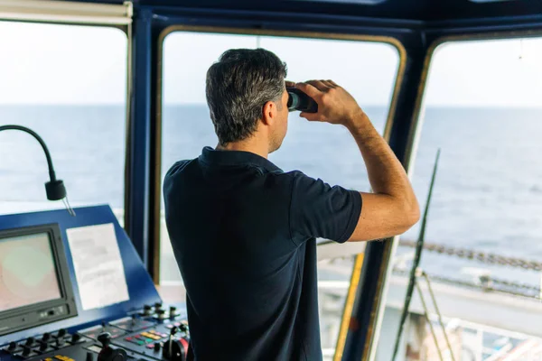 Oficial durante o relógio de navegação olhando através de binóculos — Fotografia de Stock