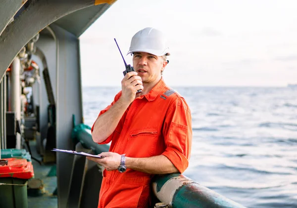 Oficial de convés no convés da embarcação offshore detém rádio walkie-talkie VHF — Fotografia de Stock