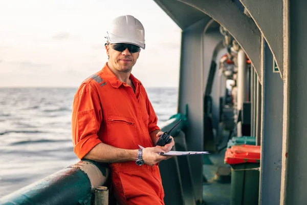 Zeevaartkundig scheepsofficier op het dek van offshore vaartuig bezit walkie-talkie marifoon — Stockfoto
