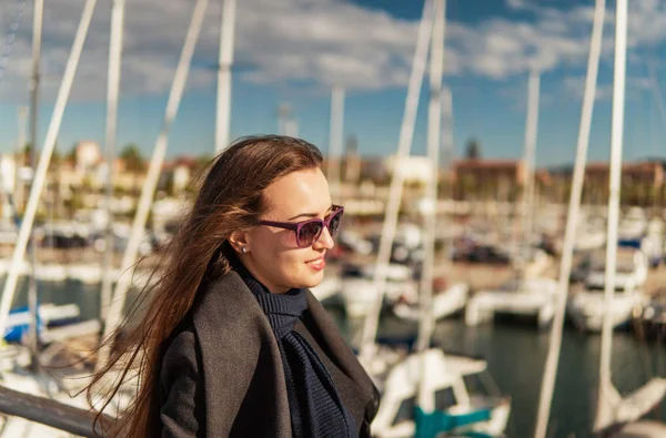 Деловая женщина в солнцезащитных очках ходит с большим количеством яхт — стоковое фото