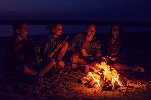 Giovani amici hanno pic-nic con falò sulla spiaggia — Foto Stock