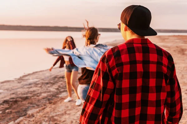 Amigos en la playa juntos caminando al atardecer — Foto de Stock