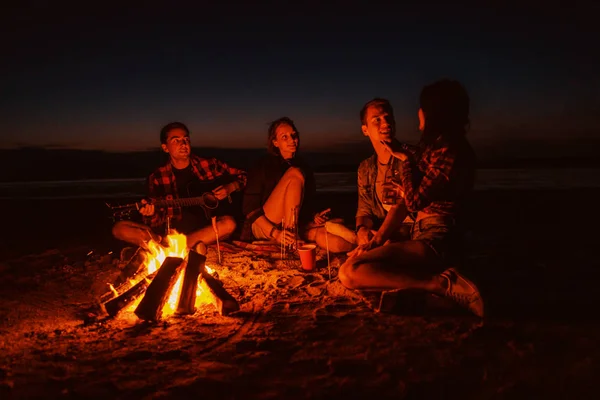 Młodzi przyjaciele urządzić sobie piknik z ogniskiem na plaży — Zdjęcie stockowe