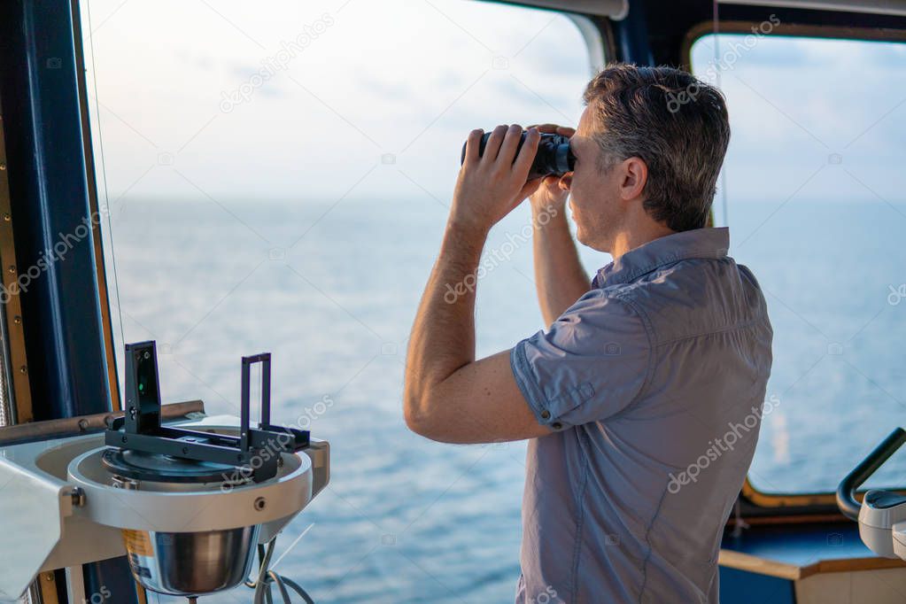 Navigational officer lookout on navigation watch with binoculars