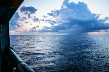 gün batımı, deniz, güneş bulutlarla kaplı. Açık okyanus manzarası