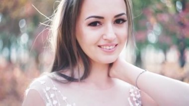 Parkta beyaz elbiseli mutlu bir gelinin portresi, yakın çekim.