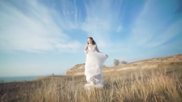 Running bride in amazing long dress through the landscape.