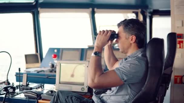 Officer during navigational watch looking through binoculars — Stock Video