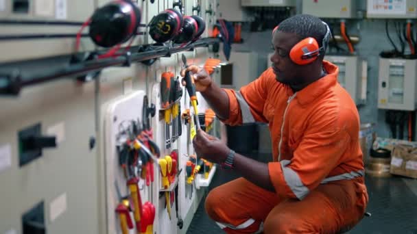African Marine engineer officer in de motor controlekamer ECR. — Stockvideo