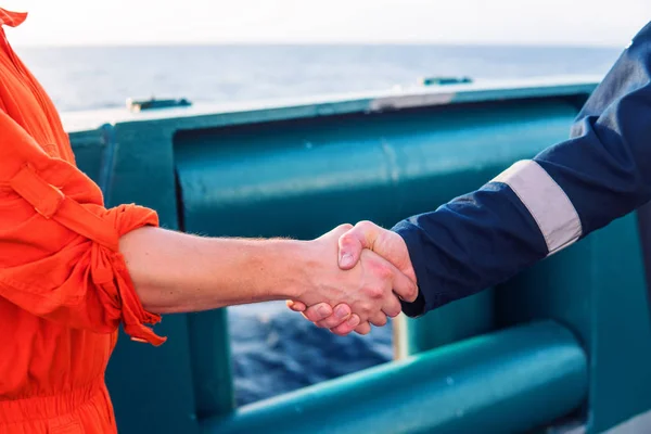 marine contractor businessman handshaking with worker on the ship.