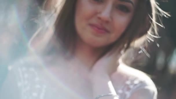 Portret szczęśliwej panny młodej w białej sukni w parku, zbliżenie. — Wideo stockowe