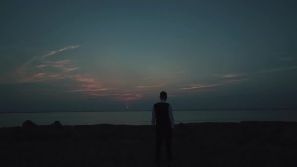 Young groom standing near the hill coast with sea on background — 비디오