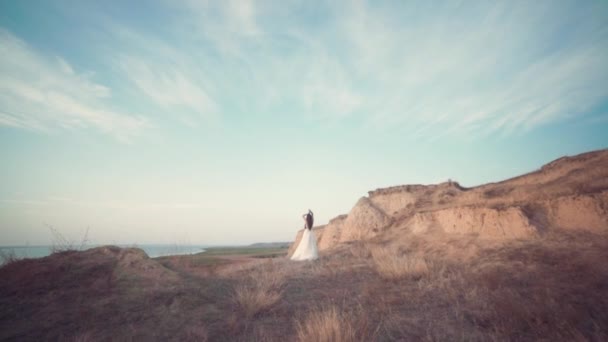 Laufende Braut in sagenhaft langem Kleid durch die Landschaft. — Stockvideo
