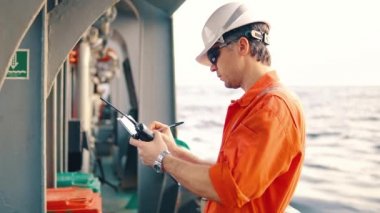 Güverte subayı offshore geminin güvertesinde Vhf telsiz telsiz tutar